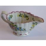 A mid-18th century Bow porcelain cream jug; hand-decorated with floral sprays and enamels above a