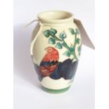 A small modern Moorcroft pottery vase of baluster form, decorated with a parrot upon a plum tree,