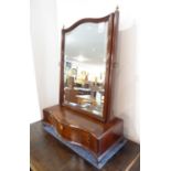 A late 18th century serpentine-fronted mahogany toilet mirror; the hand-bevelled mirror plate within