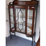 An early 20th century mahogany, marquetry and boxwood strung display cabinet: the three-quarter