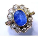 A sapphire, diamond-set and 18-carat gold ring; the oval mixed-cut sapphire collet set above the