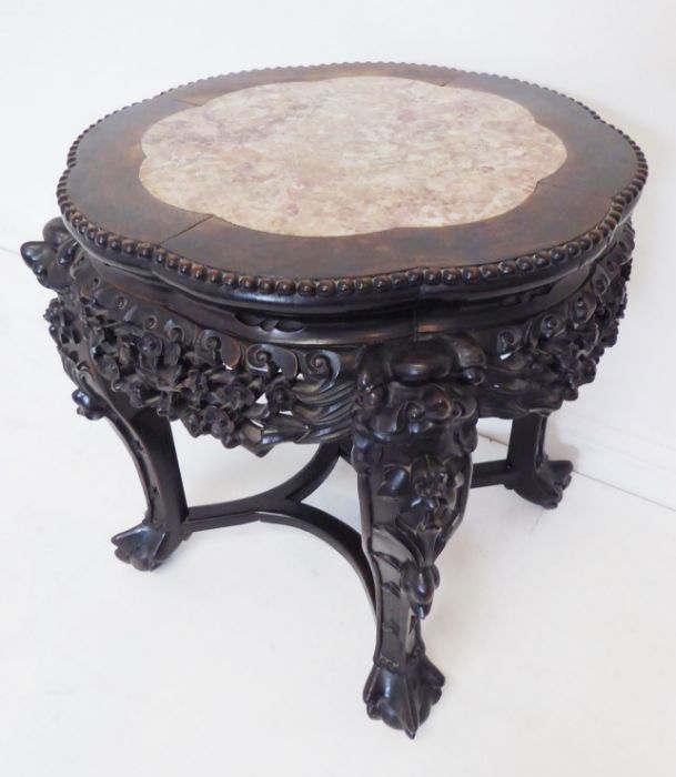 A 19th century Chinese carved hardwood and marble-topped jardinière stand; the gadrooned top with