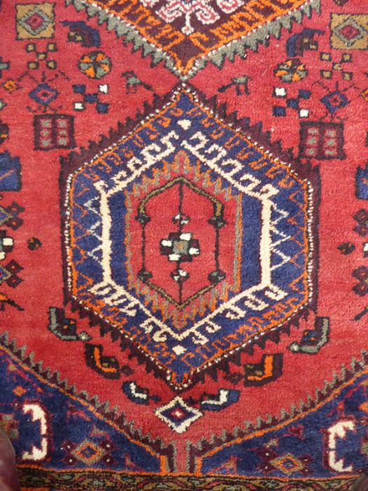 A red ground Hamadan hand knotted rug with three rug with three central lozenges against a red - Image 4 of 5