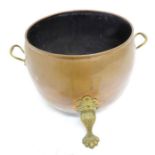 An early 20th century cauldron-type copper and brass coal bucket; twin-handled and with tripod paw-