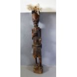 An interesting hand-carved African-style tribal figure of elongated form and with feather