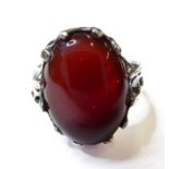 A silver dress ring centrally set with a dark red polished oval cabochon hardstone, ring size P (