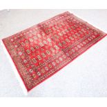 A red ground hand-knotted Pakistan Belouch carpet with gul pattern (185cm x 127cm)