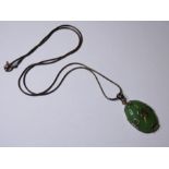 A Chinese silver and celadon jade mounted oval pendant, central conforming character mark within
