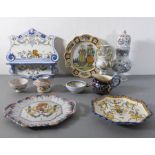 A good selection of French Quimper and faience pottery to include a shaped wall-mounting shelf, a