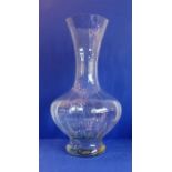 A large baluster-shaped clear glass vase, flaring neck and on circular foot