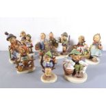 Ten various Goebel (Germany) hand-decorated porcelain figures; the largest of a young boy with a