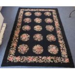 An Aubusson needlepoint tapestry; black background with 15 circular floral medallions surrounded