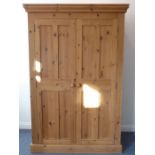 A good modern two-door pine wardrobe; the removable cornice above two panelled doors enclosing top