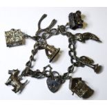A silver charm bracelet with wishing well, gypsy caravan, Holy Bible, wishbone and other charms (