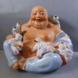 A large Chinese hand-decorated semi-glazed porcelain Buddha; of corpulent form and laughing as the