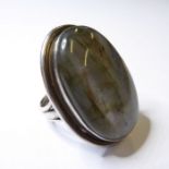 A lady's silver dress ring centrally set with a large polished cabochon hardstone resembling