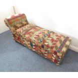 An antique day bed upholstered in a worn, early 20th century North West Persian kilim; the hinged