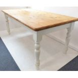 A large farmhouse-style kitchen table with natural pine top and painted base; raised on turned