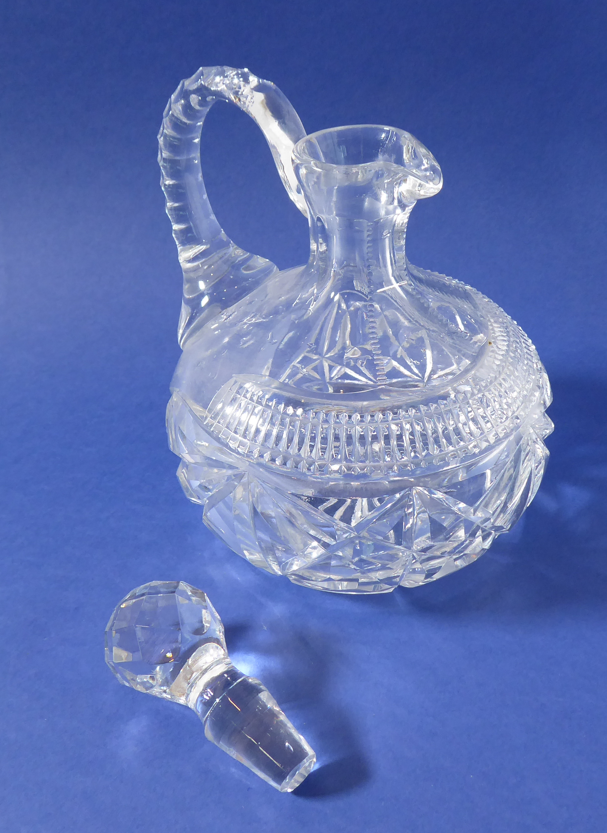 A pair of 19th century cut-glass flasks with arched faceted handles (one stopper replaced) - Image 3 of 3