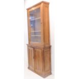 A late 19th / early 20th century oak gun cabinet; single glazed door enclosing shelves with reeded