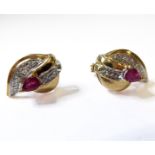 A pair of 9-carat yellow gold earrings of nautilus shell form; each set with a central ruby and