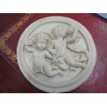 A classical-style marbleised circular wall relief depicting two winged cherubic style figures (