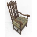 A late 17th century style (a good reproduction) open-armed carved walnut armchair of generous