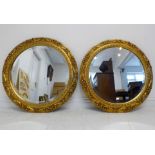 A pair of antique-style (reproduction) circular gilt-framed wall-hanging looking glasses having