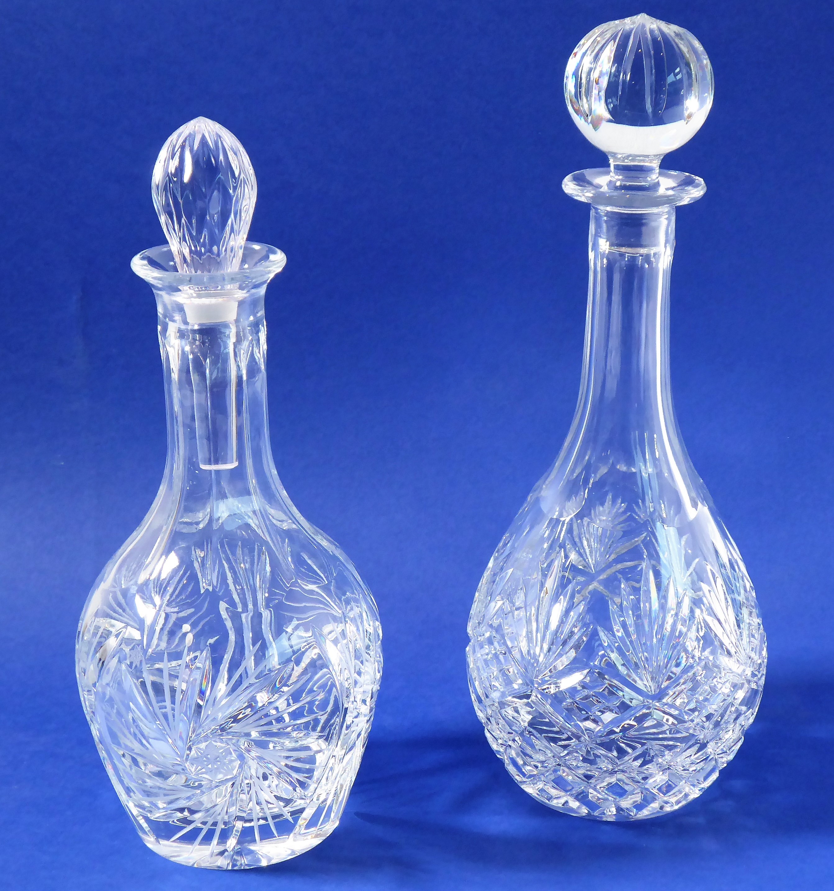 Two fine quality hand-cut baluster-shaped decanters; one with replaced stopper