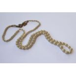 A graduated cultured pearl necklace with a diamond and pearl clasp