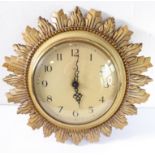 A mid-20th century electric sunburst-style clock by Smiths