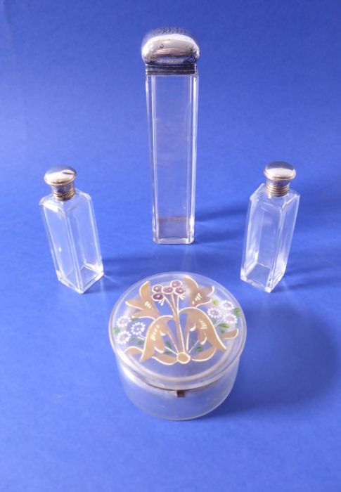 A late 19th/early 20th century rectangular cut-glass requisite bottle with silver lid, two smaller