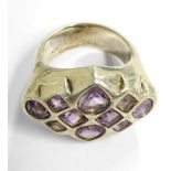 A large, unusual and heavy silver dress ring set with ten hand-cut amethyst-coloured stones of
