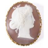 An oval shell cameo brooch/pendant depicting the head of a classical lady looking right within a