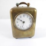 A late 19th/early 20th century brass cased bedside-style clock; carrying handle above white dial