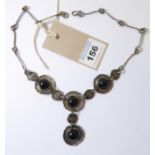 A continental silver necklace set with five circular black en-cabochon hardstones polished on