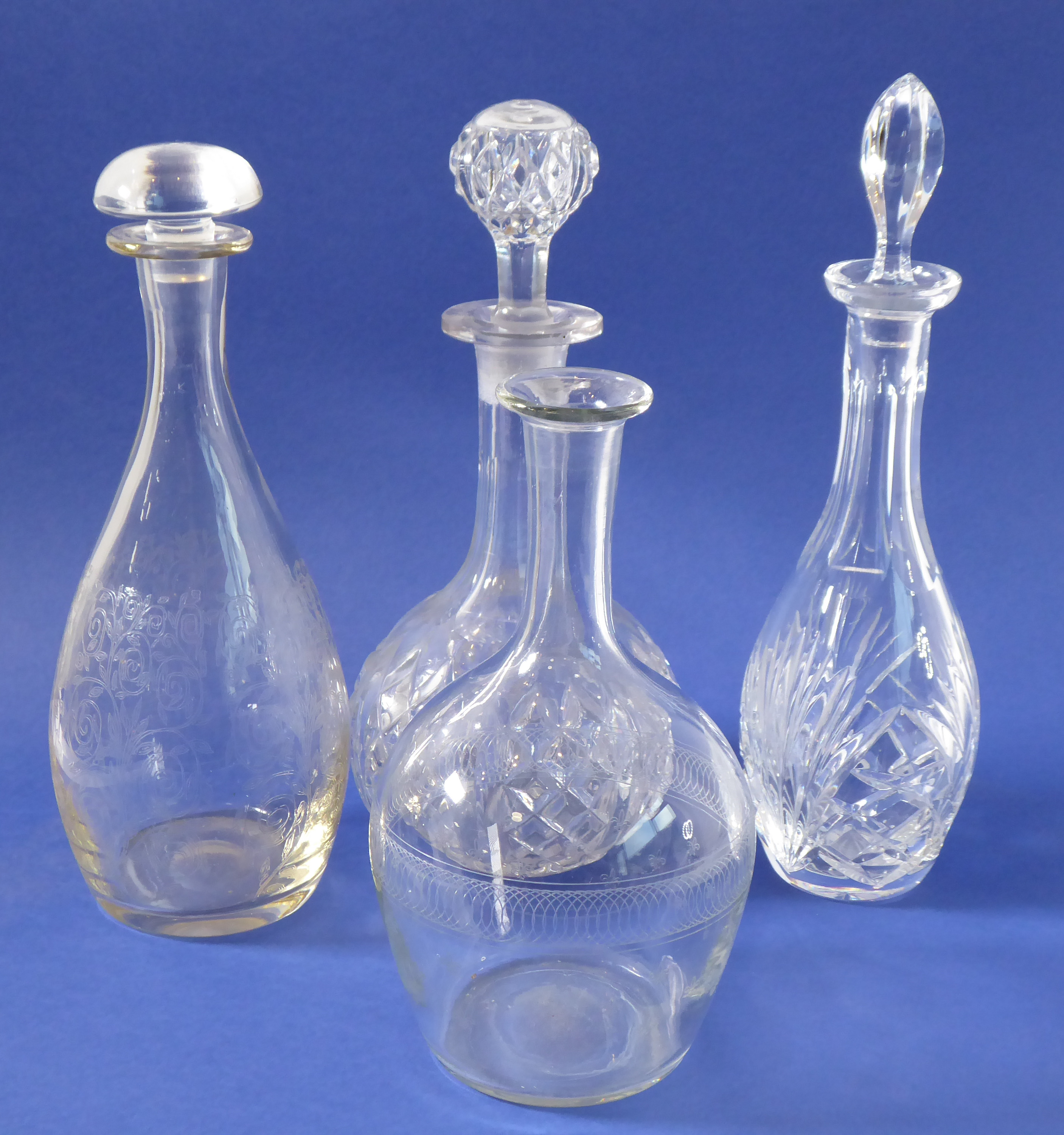 Four decanters to include a globe-and-shaft example, a 'skittle' shaped example (both hand-cut),