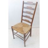 An Arts and Crafts style stained beech ladderback chair having rush-woven seat and in the style of