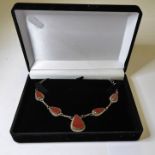 A silver necklace mounted with five teardrop-shaped polished red hardstones (possibly carnelian) (in