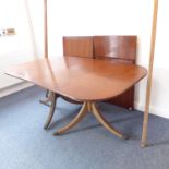 A large extending mahogany dining table with two extra leaves in George IV Regency style; the reeded