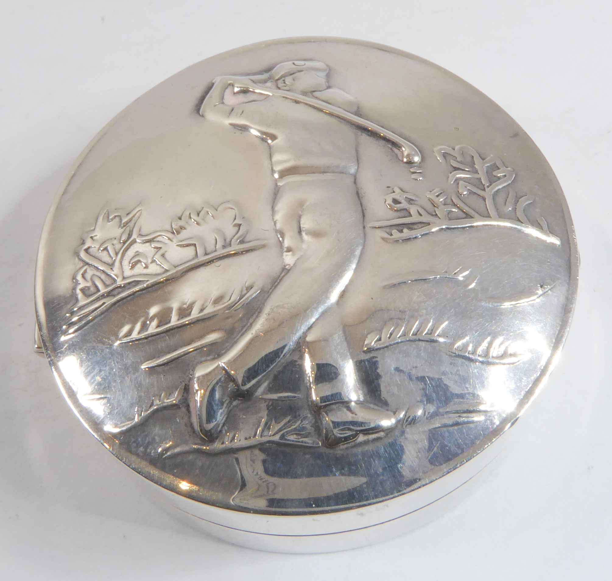 A silver pill box  –  the top embossed with a male golfer, import marks for Sheffield assay office