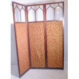 An Edwardian mahogany and upholstered two-fold room screen with Gothic-style astragal glazing