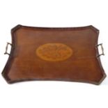 A concave-sided mahogany serving tray with two darkly patinated angular brass carrying handles,