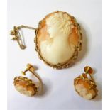 An oval cameo and a pair of earrings en suite each depicting the head and shoulders of a lady with