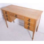 A late 18th century style (later) heavy beech writing/dressing table; the overhanging top above an