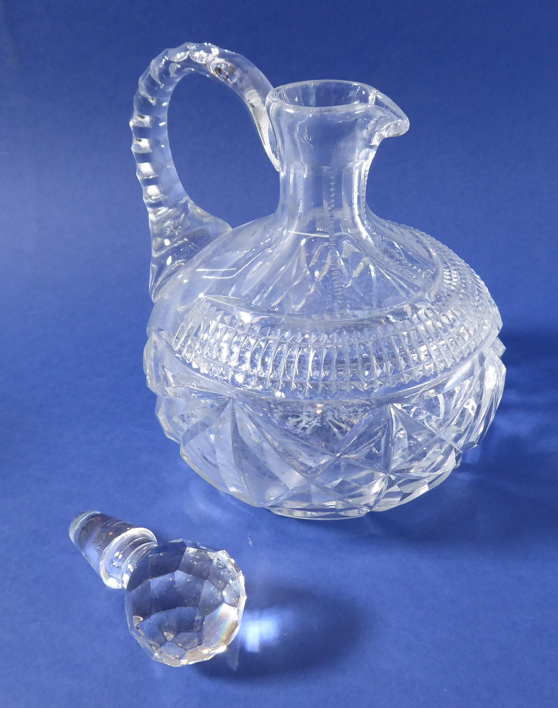 A pair of 19th century cut-glass flasks with arched faceted handles (one stopper replaced) - Image 2 of 3