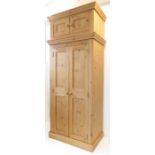 A pine wardrobe with separate two-door cupboard top above (99 x 64 x 238cm - the wardrobe 193cm high