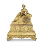 "LEILA". PENDULE en bronze doré représentant Leila alanguie le coude appuyé sur un coussin, les
