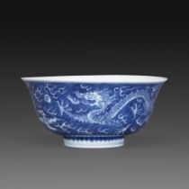 COUPE en porcelaine émaillée en bleu sous couverte, à décor en réserve de deux dragons à cinq