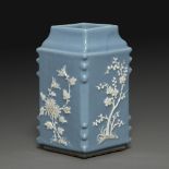 VASE QUADRANGULAIRE en porcelaine émaillée bleu ciel, les quatre parois décorées en léger relief